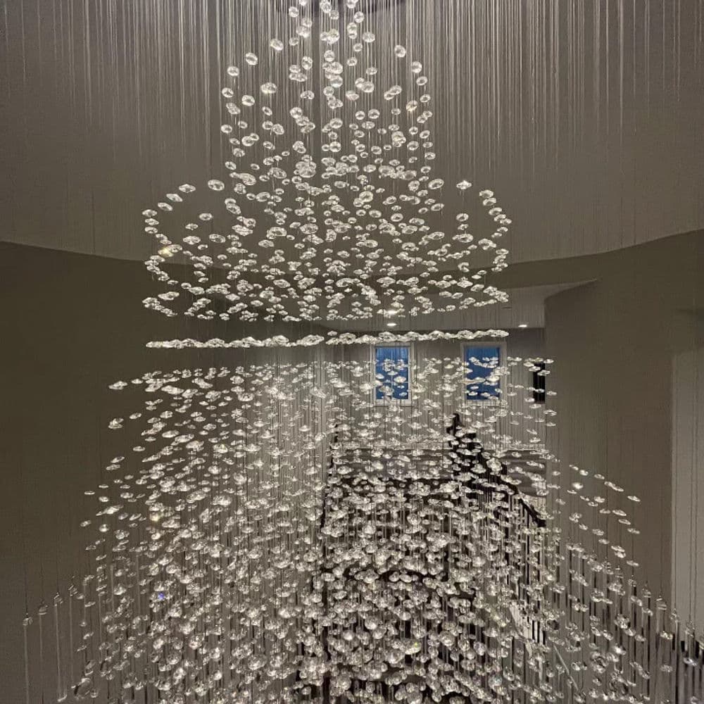 Stunning crystal chandelier cascading from the ceiling, enhancing modern interior design.